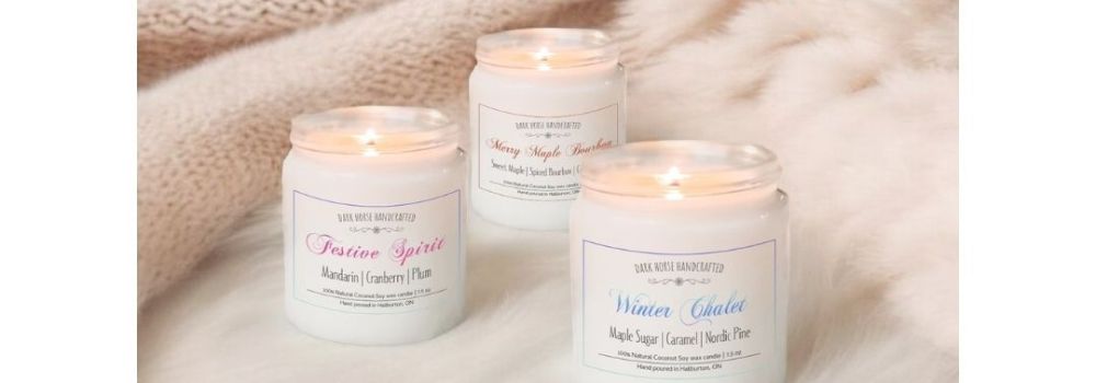 3 lit candles in jars on a blanket