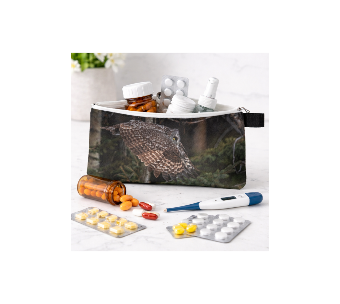 Zippered pouch with great gray owl design containing medical supplies on a white background.