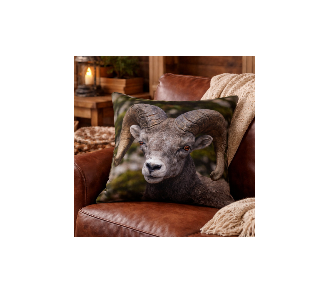 Decorative throw pillow cover with an image of a big horn ram design with a green gray background brown leather couch.