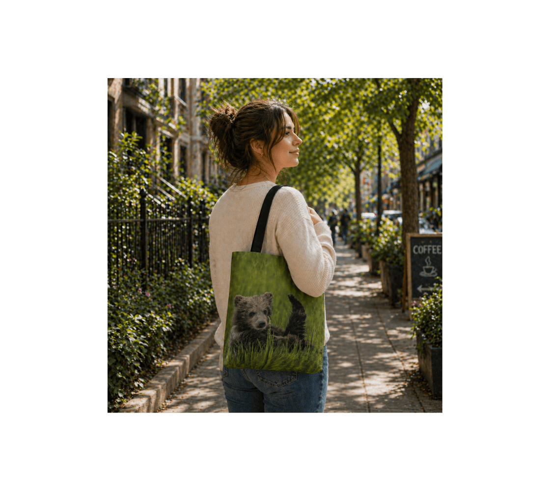 A woman walking carrying a brown bear cub medium reusable tote bag from our real wildlife photography.