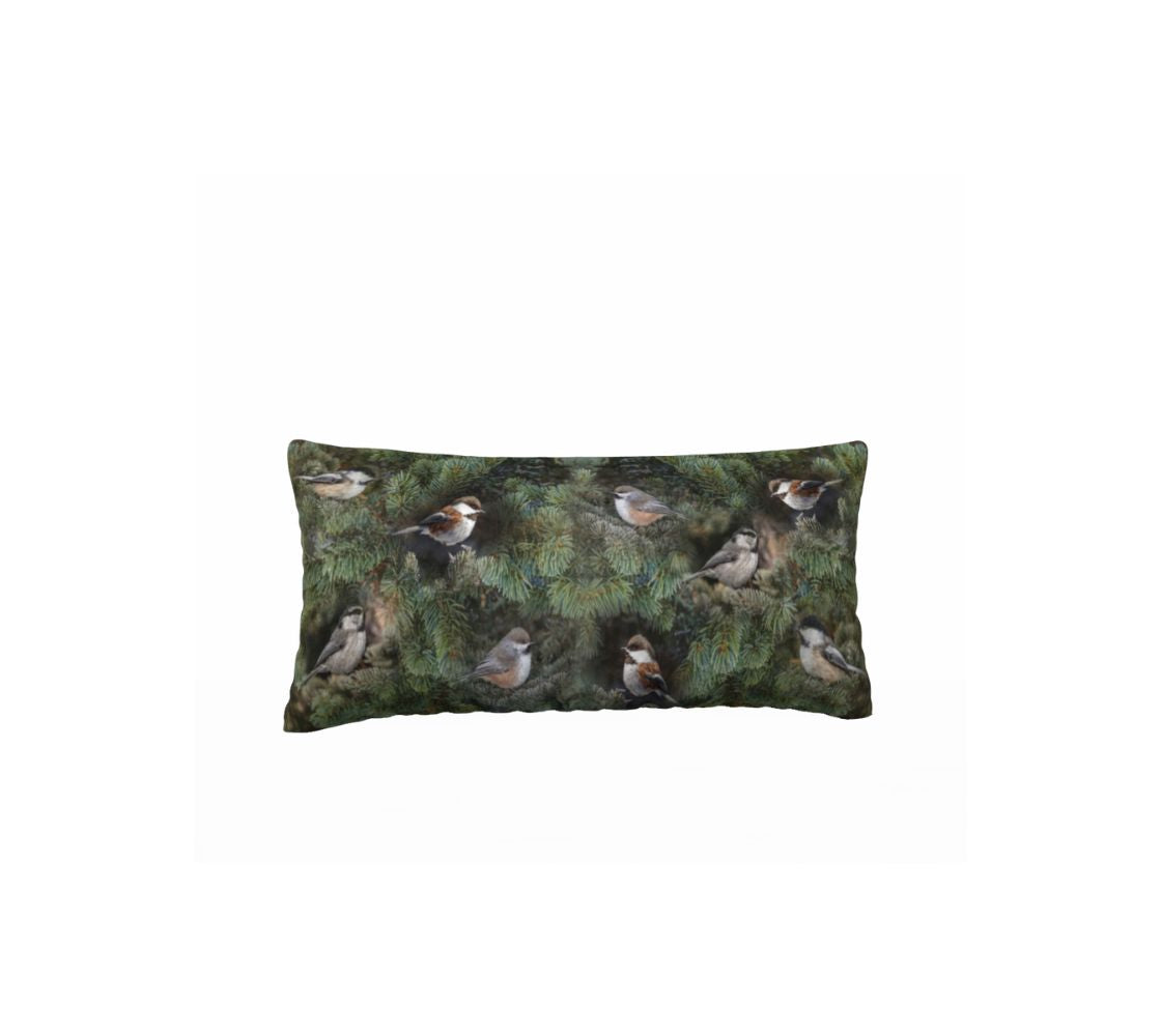 This is an image of a 12 x 24 inch plush velveteen cushion cover featuring a photo of the 4 chickadees of Western Canada on a background of green pine boughs.