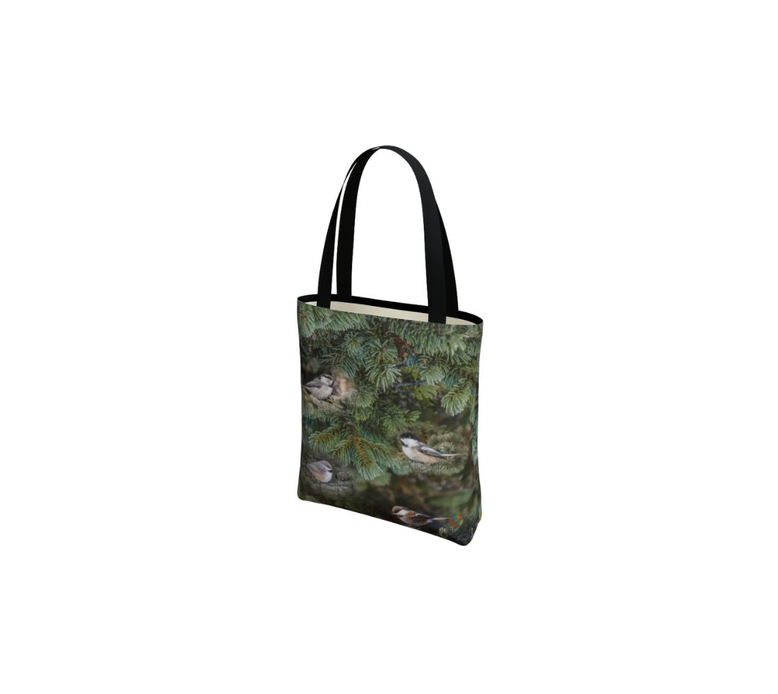 This is an image of small canvas market bag featuring a photo of green tree boughs in the background with a repeating photo collage of the four different chickadees of Western Canada in their colorful black, brown, white, rust and grey tones. The bag has two 1.5" wide black straps with a white interior.