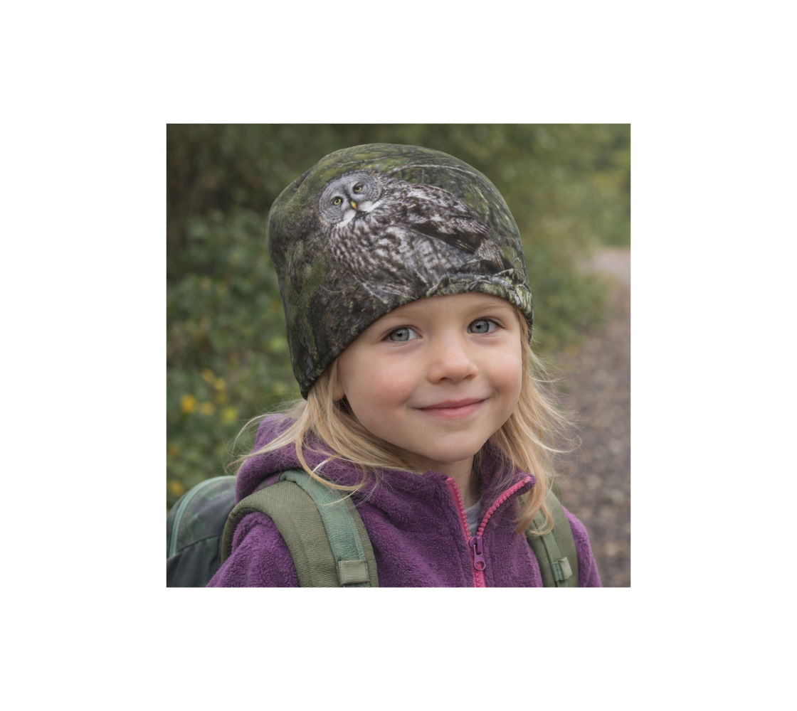 Young girl hiking in nature wearing a beanie with an image of great gray owl.