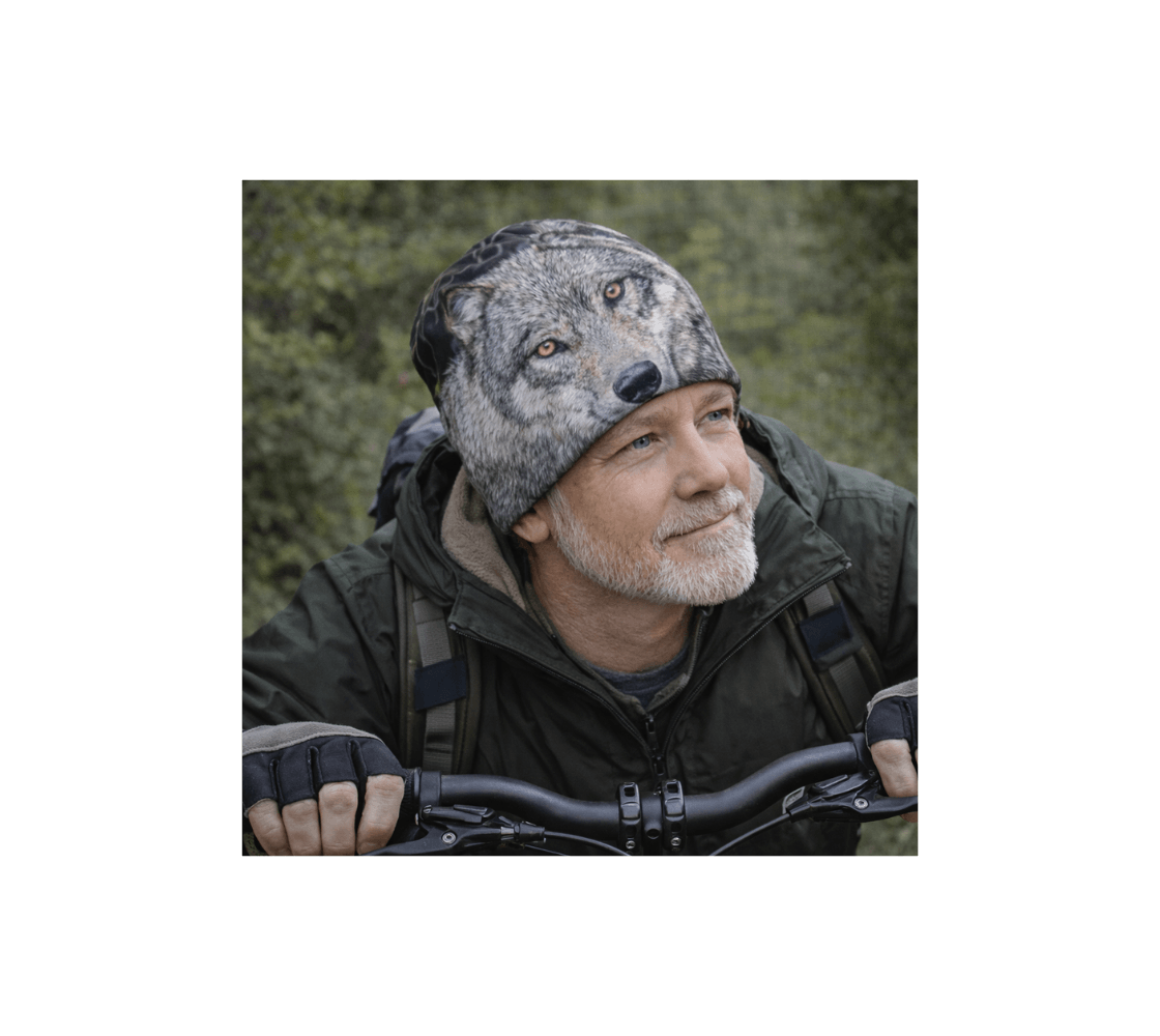 A elderly man wearing a gray wolf bamboo-lined beanie from our Canadian wildlife photography riding bicycle in a forests.