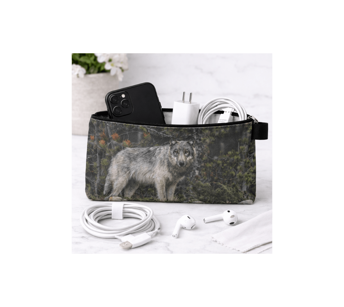 A zippered pouch with a gray wolf design from our wildlife photography with electronic accessories inside it.