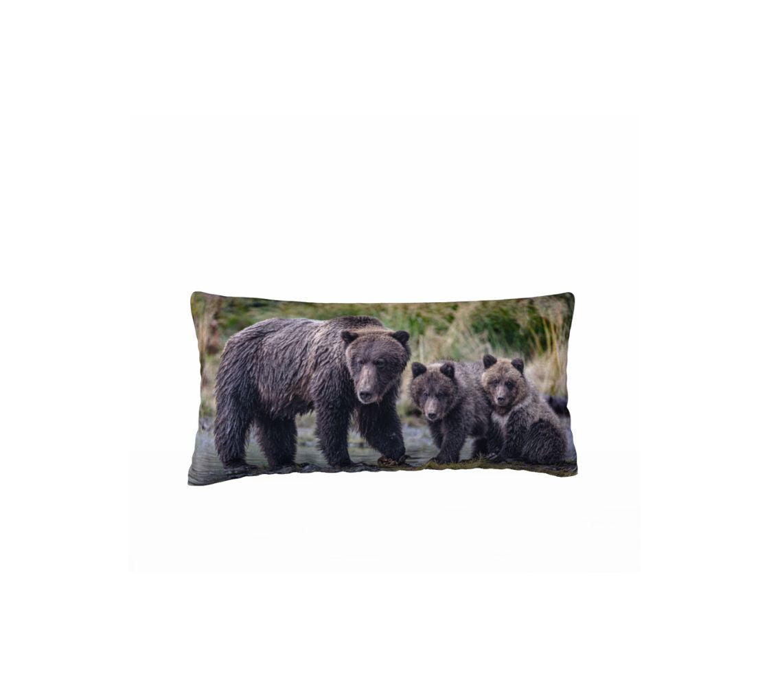 This 12 x 24 inch plush velveteen cushion cover is a photo of a dark brown grizzly mama and her 2 cubs watching us. The cushion cover background is tall green and yellow grass with the blue river's edge that the bear family is standing in.