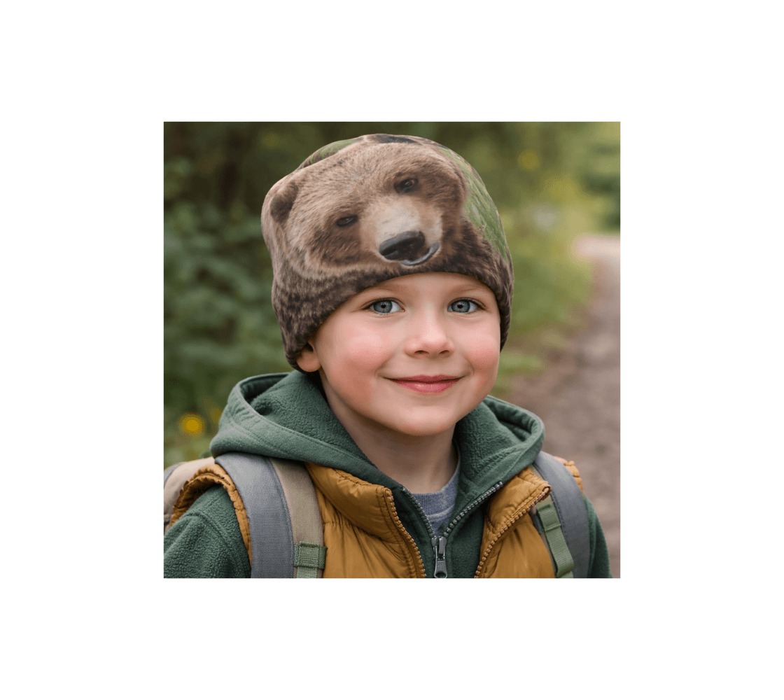 A young boy standing in nature wearing a grizzly bear beanie from our Canadian photography.