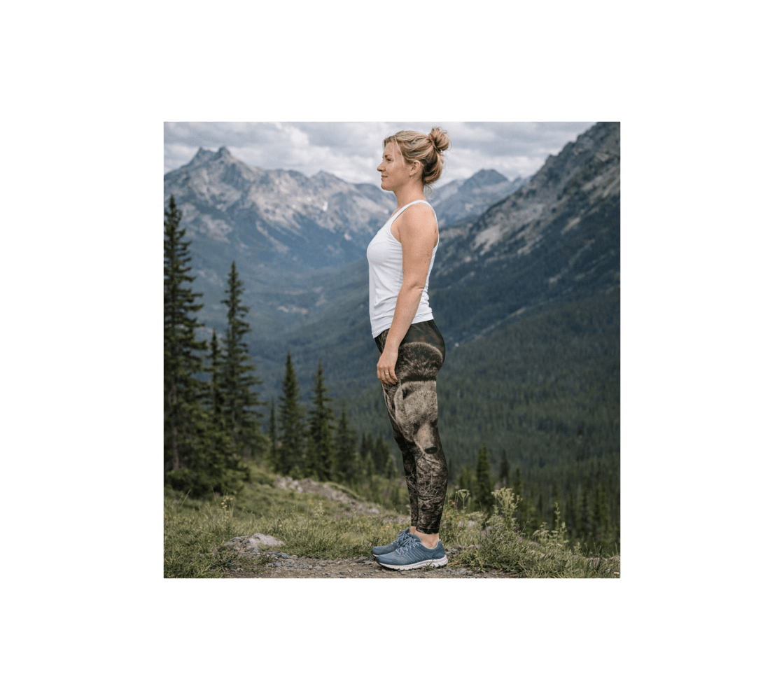 A woman standing in the mountains wearing a pair of grizzly bear classic leggings from our real wildlife photography.
