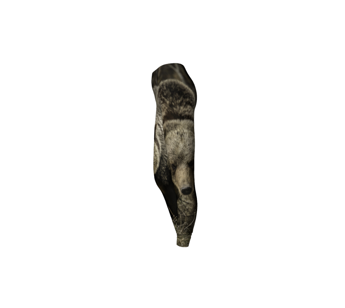 This is a side profile of a pair of classic leggings featuring a photo of a grizzly bear on each leg, with a 1.5 inch wide elastic waistband. The image is a close up of a large multi-colored brown girzzly bear coming towards you.