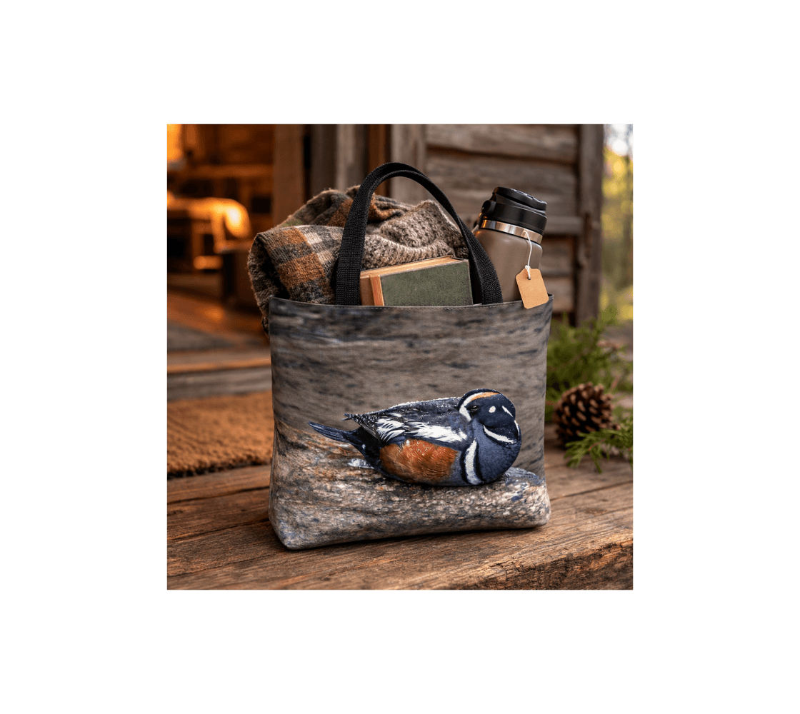 A male harlequin duck medium reusable tote bag from our real wildlife photography with a blanket and thermos inside it.