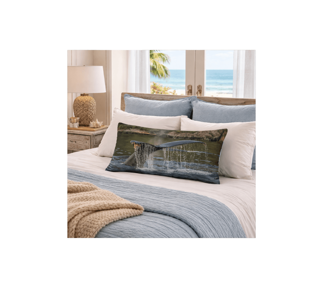 A decorative long throw pillow cover with a humpback whale tail design from our photography on a bad.