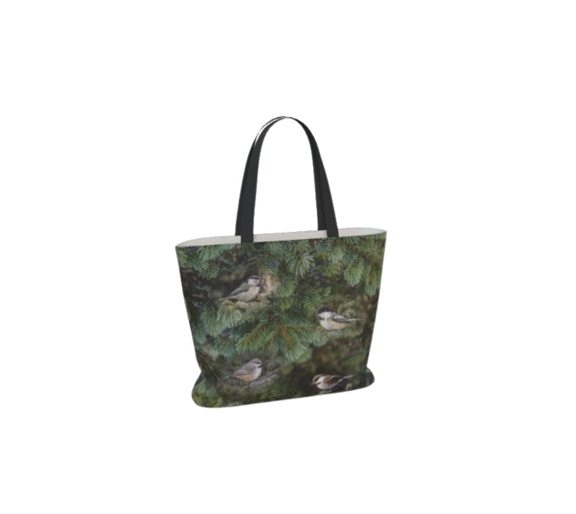 This is an image of large canvas market bag featuring the same photo on each side of green tree boughs in the background with a repeating photo collage of the four different chickadees of Western Canada in their colorful black, brown, white, rust and grey tones. The bag has two 1.5" wide black straps with a white interior.