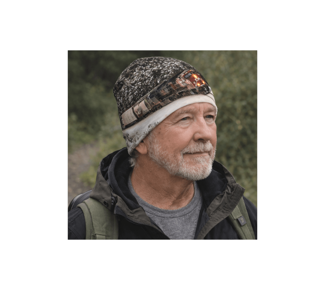 A man wearing a train at Morant's Curve beanie from our Canadian photography standing in forest .
