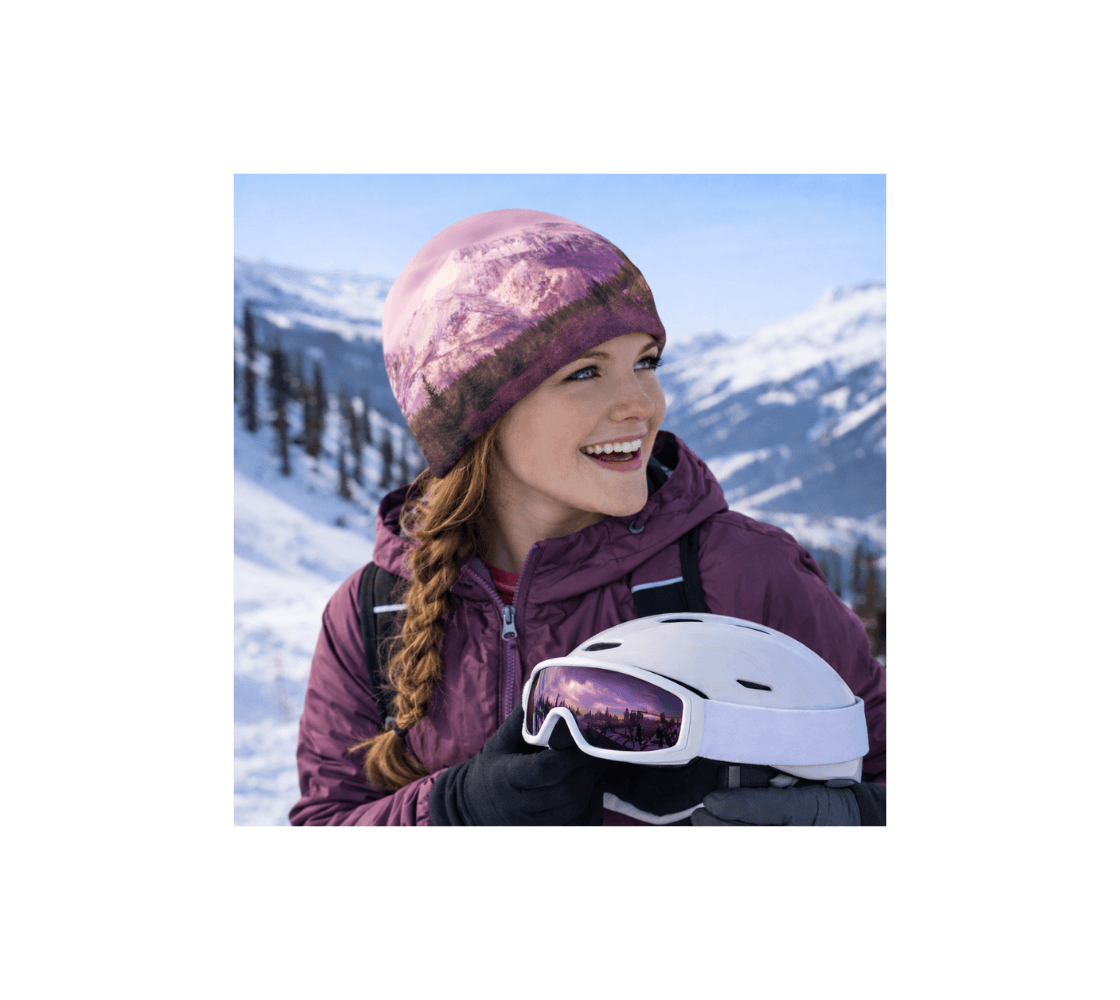 A lady wearing a pink mountain beanie from our original nature photography while boarding in the mountains.
