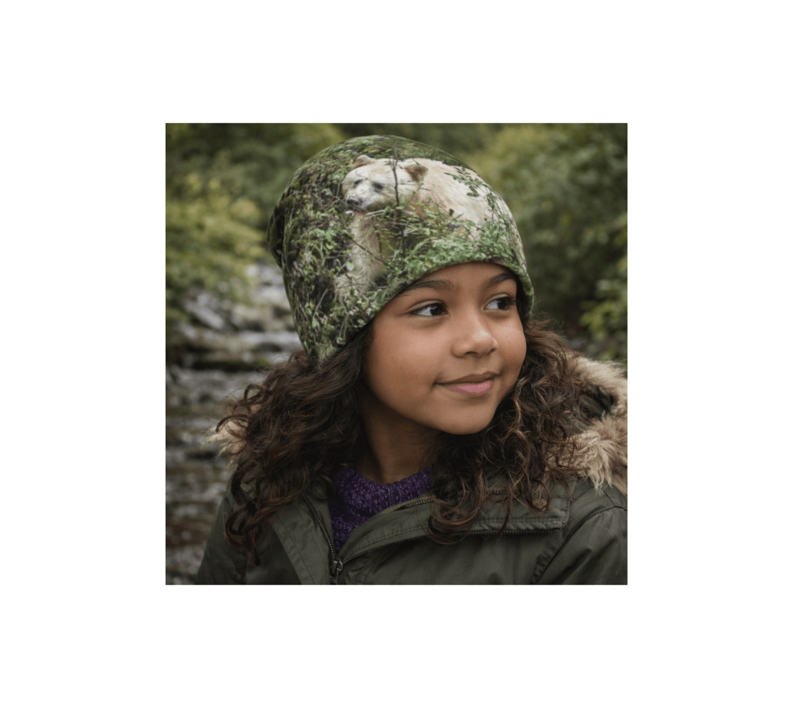 A young girl wearing a spirit bear bamboo-lined beanie from our wildlife photography standing by creek.