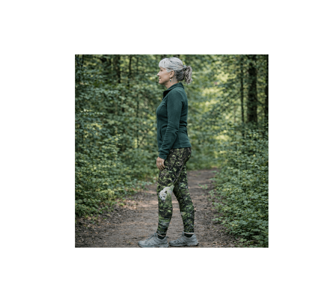 A woman standing in the forest wearing a pair of spirit bear classic leggings from our wildlife photography.