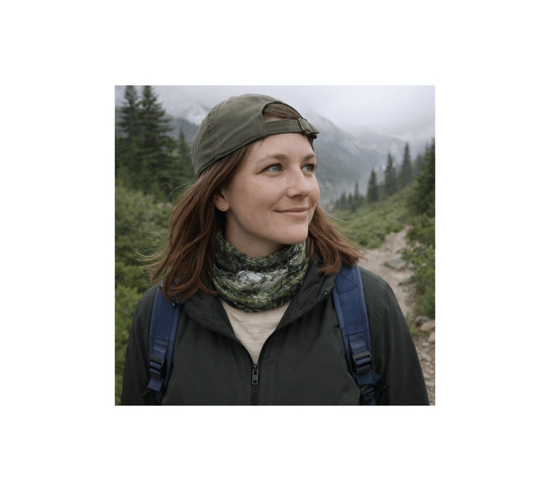 Woman hiking in a forest wearing a spirit bear head and neck buff from our wildlife photography around her neck.
