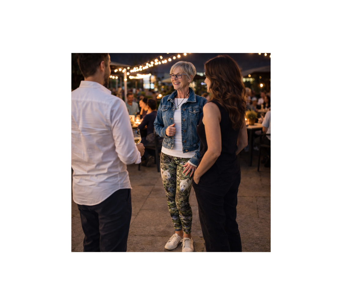 A women standing wearing a pair of spirit bear yoga leggings from our wildlife photography with a woman and a man in nightclub setting.