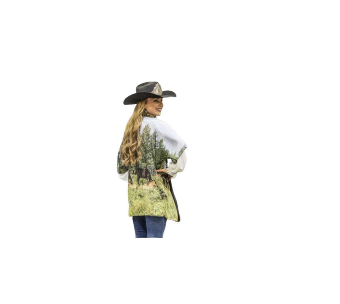This is an image of a young cowgirl wearing a semi-sheer poly chiffon kimono robe featuring a photo of wild horses. The background is  of a blue sky, green trees and grass with wild foals lying among the wildflowers and many wild horses grazing in the field. Kimono has black trim and a black lightweight bamboo belt for tying.