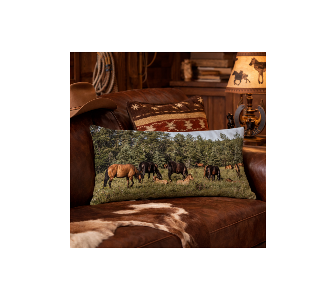 A western style living room with a band of wild horses decorative long throw pillow from our wildlife photography on a brown leather couch.