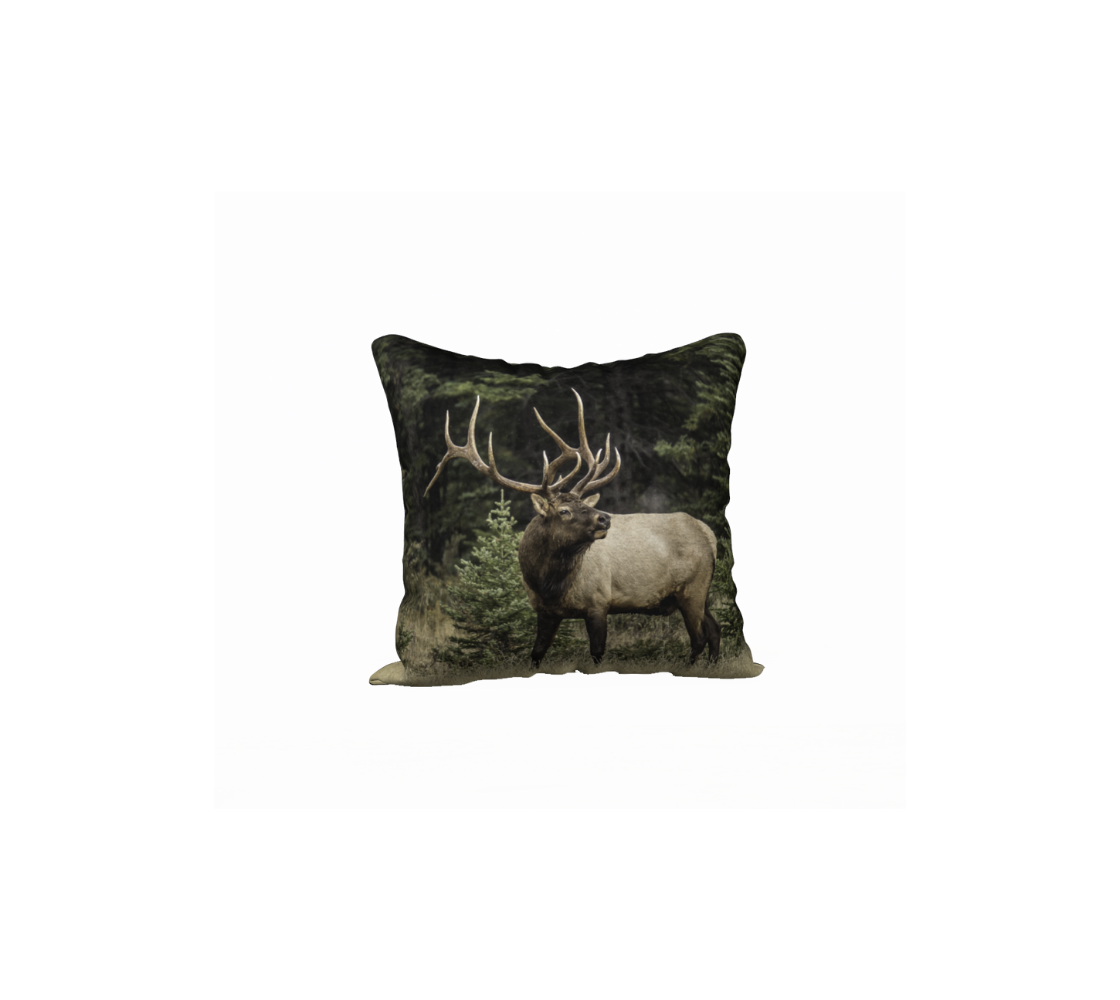 This 18 x 18 inch plush velveteen cushion cover features a photo of a two toned brown bull elk, with large antlers, standing with its head turned as it is bugling with exhaust coming from his mouth. The background is the green and golden tones of the autumn forest.