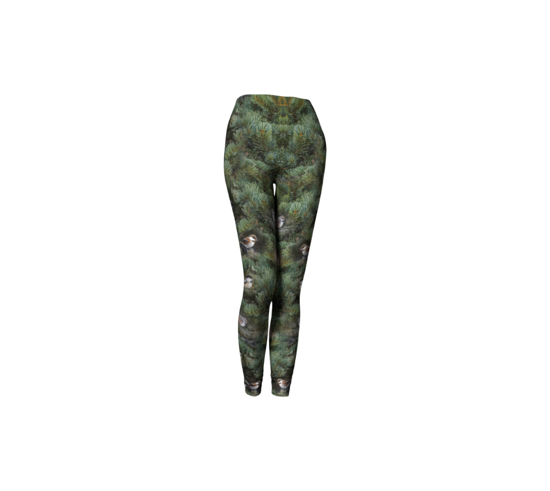 This is an image of a front profile of a pair of leggings featuring a photo of green tree boughs in the background with a repeating collage of the four different chickadees of Western Canada in their colorful black, brown, white, rust and grey tones.