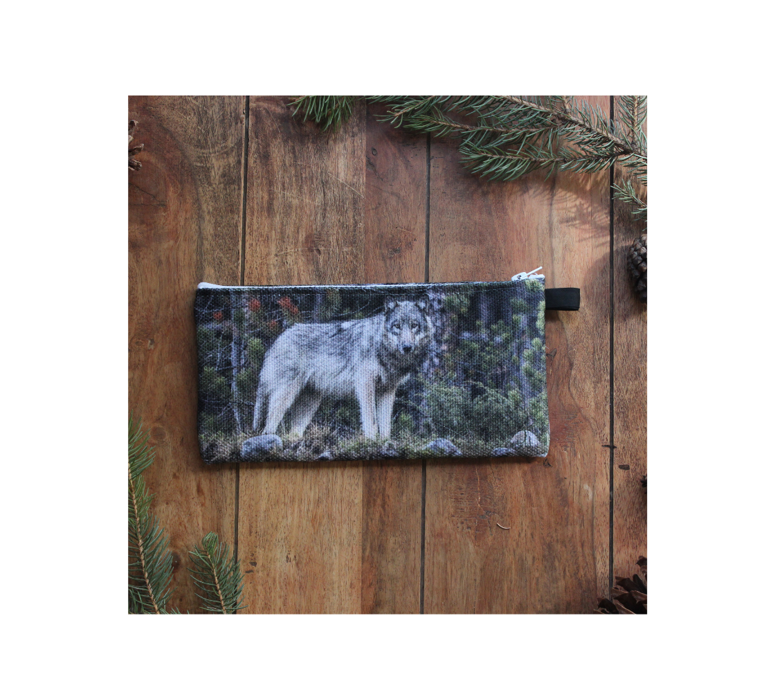 Durable double sided 9” x 4” canvas zippered pouch featuring real images of grey wolf in rocky Mountains.