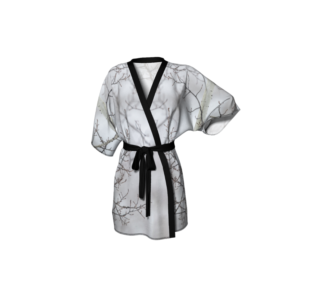 This is a frontview of a semi-sheer lightweight poly chiffon kimono robe featuring a photo of branches. Background is white and grey, with blurred tree branches due to the fog and frost at the time of the photo. Kimono has black trim with a black lightweight  bamboo belt for tying.
