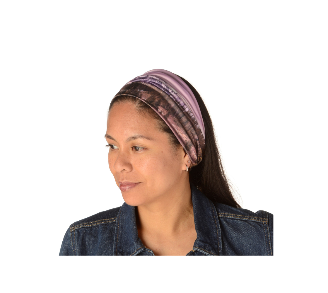 This is an image of a woman wearing a photo of a pink mountain scene on a head and neck band worn as a headband. The scene is of a snow covered mountain in the far distance with a meandering stream winding its way through the fall colored willow and forest of evergreen trees towards the mountain. A special filter used when taking this photograph created an over all pink hue to the image that really accentuated the sunset light at the time.
