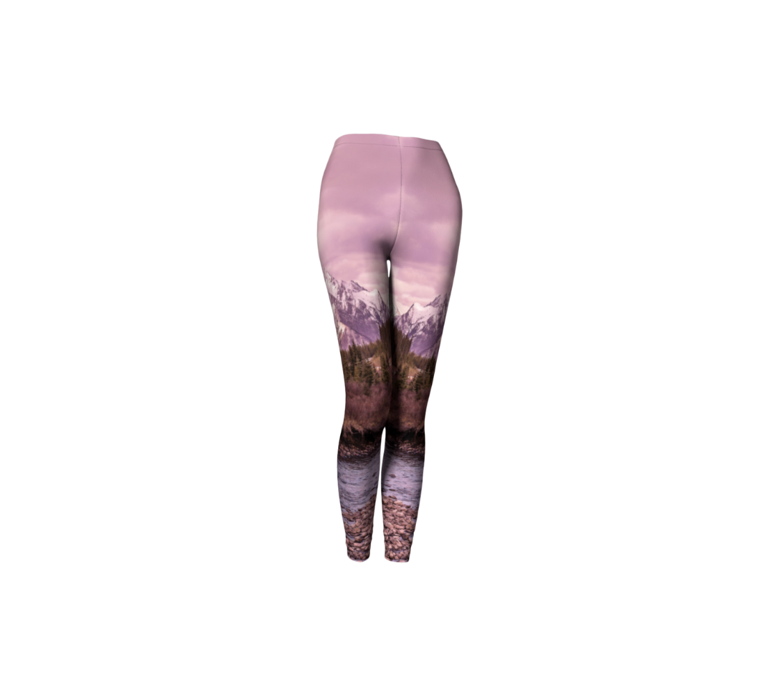 This is a front profile of a pair of classic leggings featuring a photo of a pink mountain scene, with a 1.5" wide elastic waistband.  The scene is of a snow covered mountain in the far distance with a meandering stream winding its way through the fall colored willow and forest of evergreen trees towards the mountain. A special filter used when taking this photograph created an over all pink hue to the image that really accentuated the sunset light at the time.