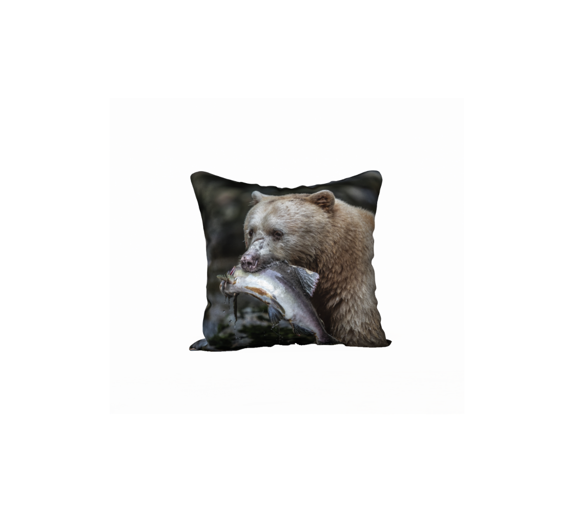 This 18 x 18 inch plush velveteen cushion cover features a photo of a white spirit bear holding a light grey salmon in her mouth. The background is mottled green and grey tones with a mossy rock.