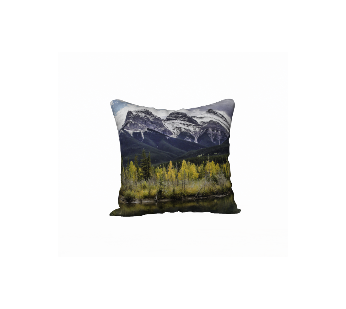 This 18 x 18 inch plush velveteen cushion cover features a photo of an autumn scene of the Three Sisters Mountain with a little snow on the peaks. The cushion cover background is blue sky, clouds green tree on the mountain with yellow aspen trees in the foreground along the river's edge.