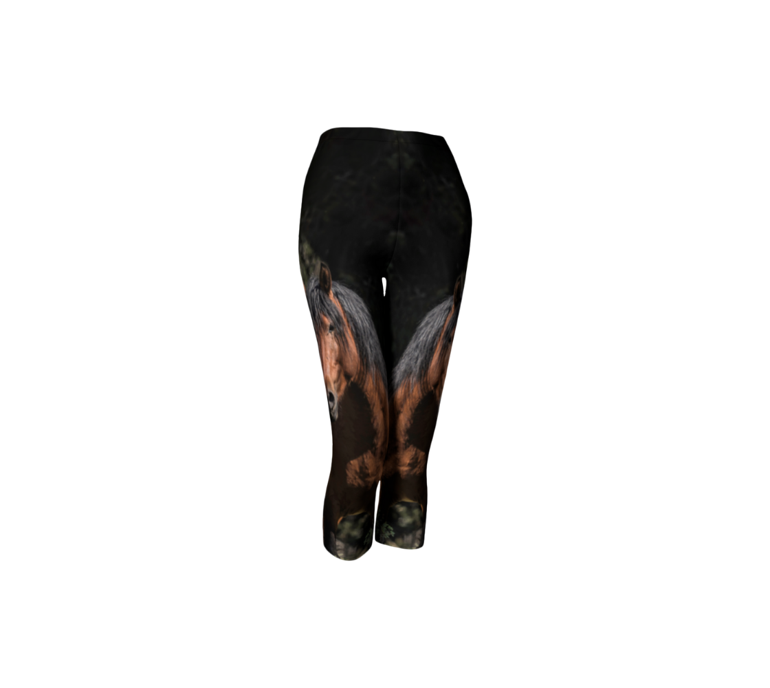 A front profile of 3 quarter length capri leggings with a 1.5 inch elastic waistband, featuring a photo of a wild stallion. The background is dark green/black at the top with green grass at the bottom, with an portrait image of a chestnut brown wild horse with a black mane and tail.