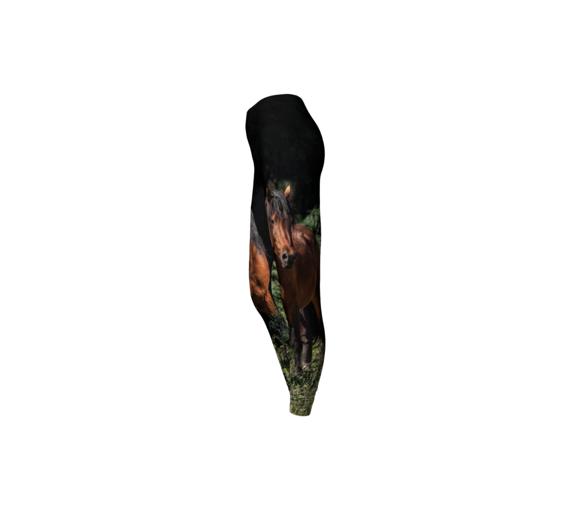 A side profile of leggings featuring a wild stallion with a 1.5" elastic waistband. The background is dark green/black at the top with green grass at the bottom, with an portrait image of a chestnut brown wild horse with a black mane and tail.