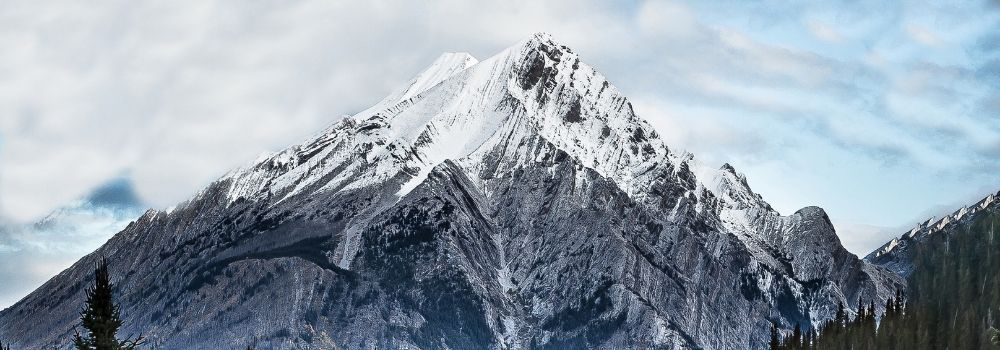 A mountain scene with a cloudy blue sky.