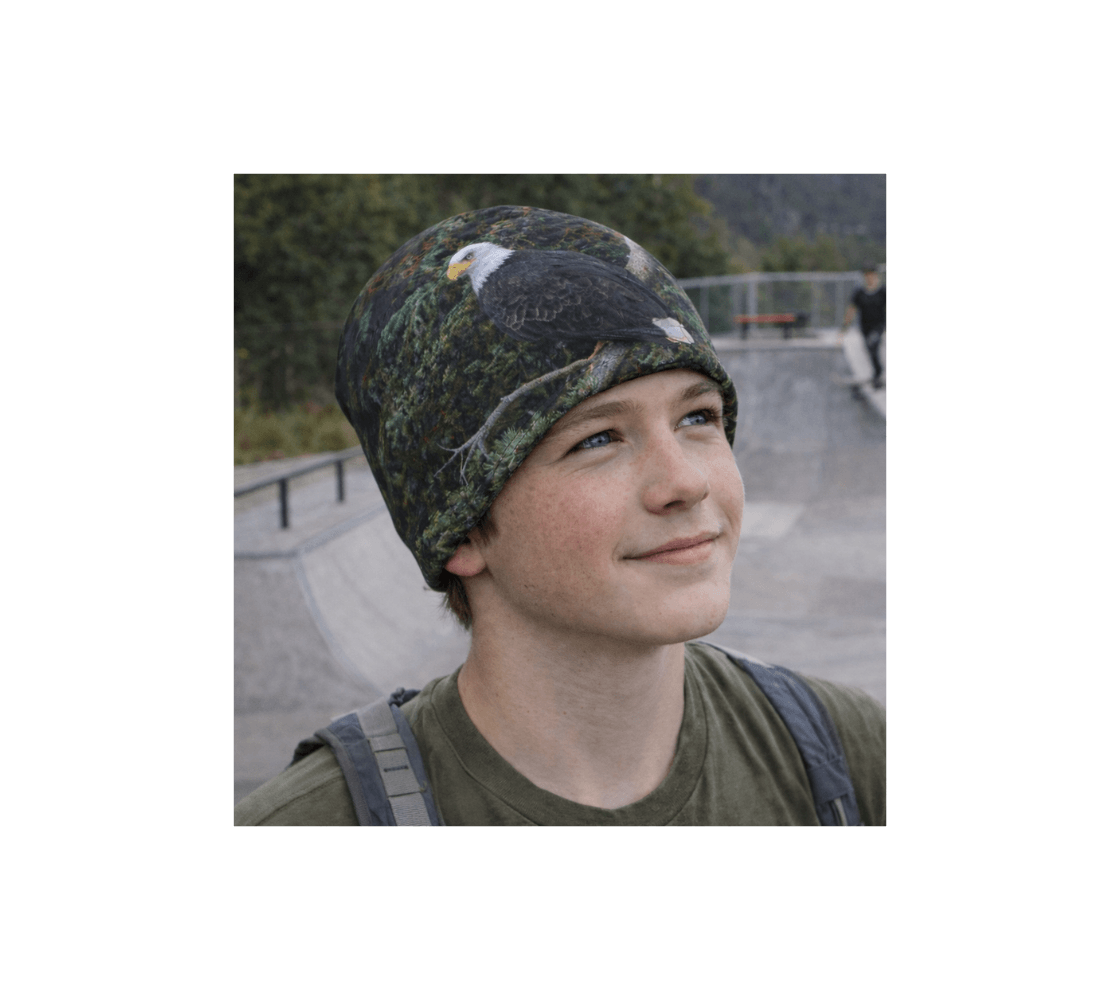 A young boy wearing a bald eagle bamboo-lined beanie with our original wildlife photography at skat park.