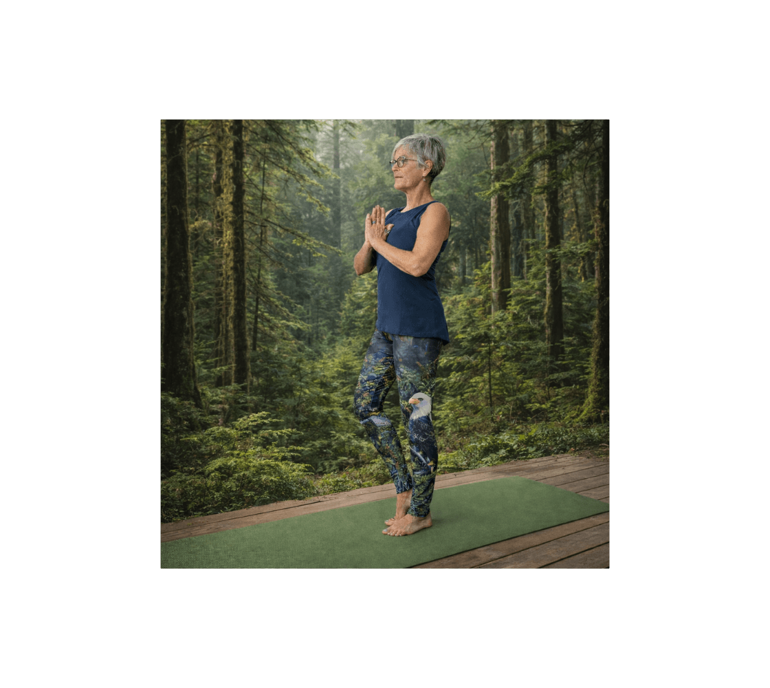 A woman practicing yoga wearing a pair of bald eagle yoga leggings from our wildlife photography in forest setting.