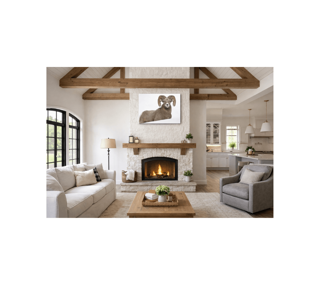 A cozy living room with a canvas print of a bighorn ram from our wildlife photography hanging on a white stone fireplace.