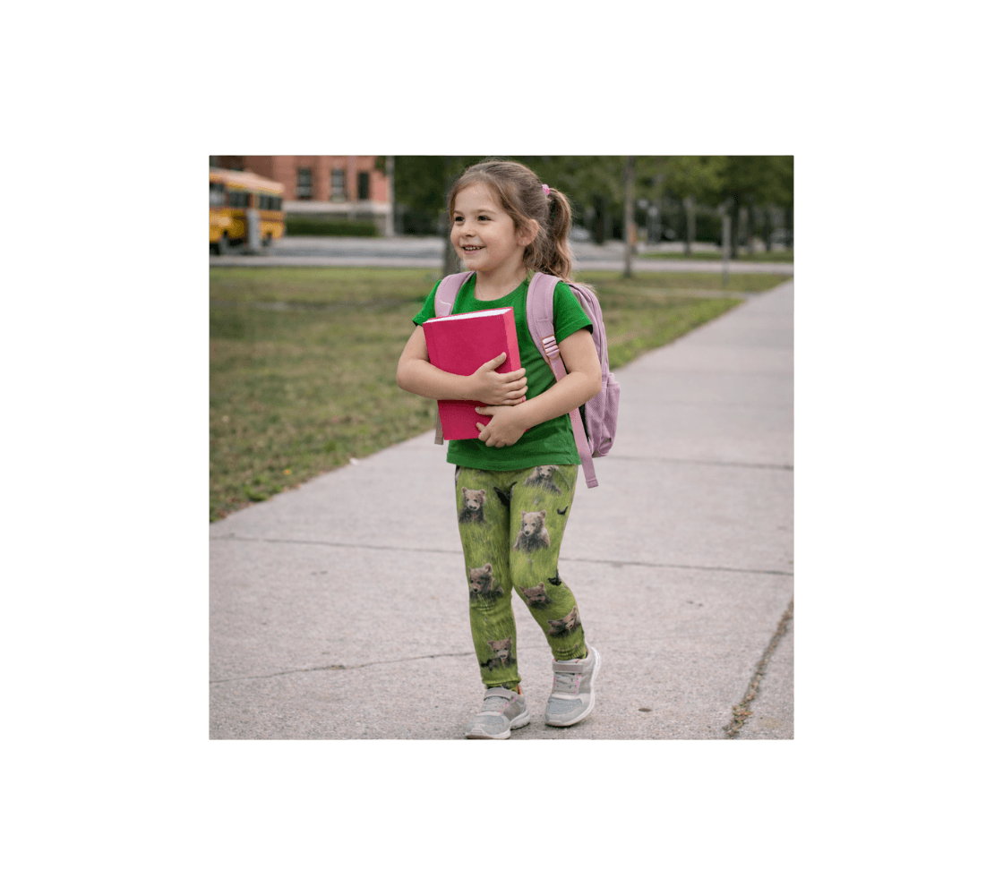 A young girl walking wearing a pair of brown bear cubs youth leggings from our wildlife photography from a school.
