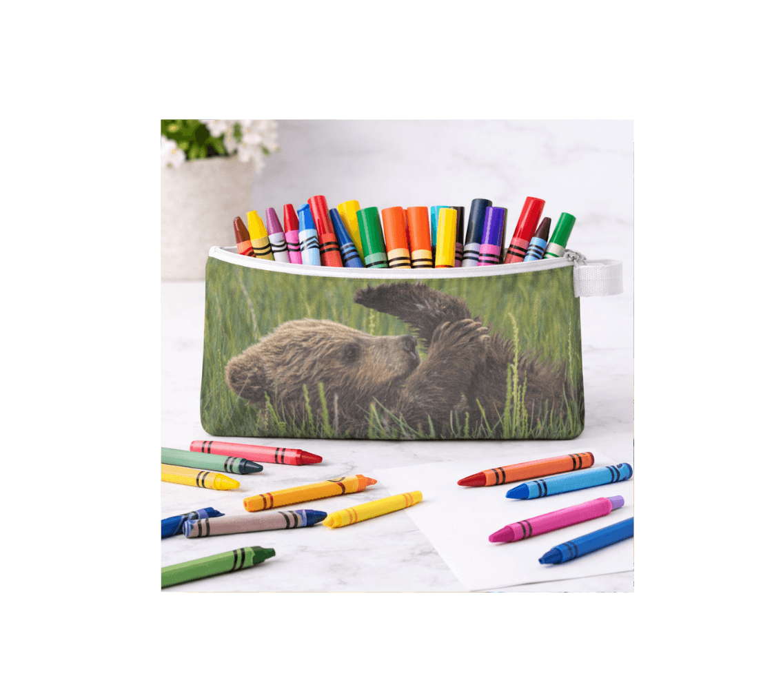 A Zippered pouch with a brown bear cub design from our wildlife photography with crayons inside it.