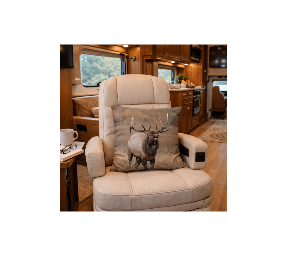 A motorhome with a bull elk decorative throw pillow cover from our Canadian wildlife photography on a beige recliner.