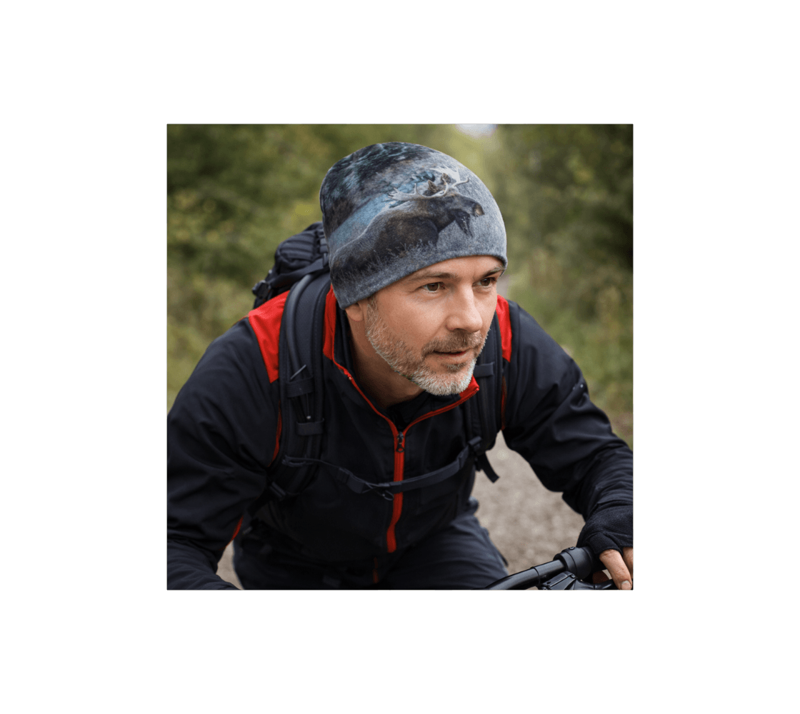 A man wearing a bull moose bamboo-lined beanie from our wildlife photography riding a bicycle in a forest.