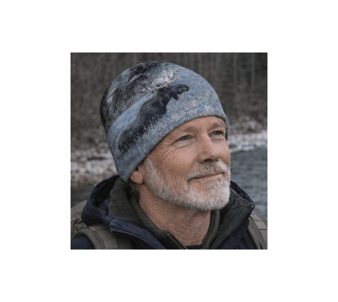 A man wearing a bull moose bamboo-lined beanie from our original Canadian wildlife photography standing in a forest.