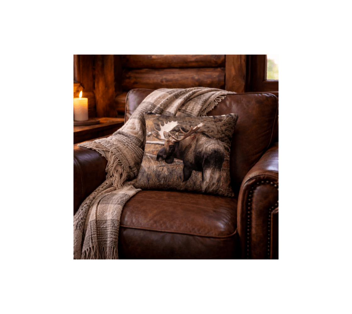 A rustic cabin with a bull moose decorative throw pillow cover from our wildlife photography in a brown leather chair. 