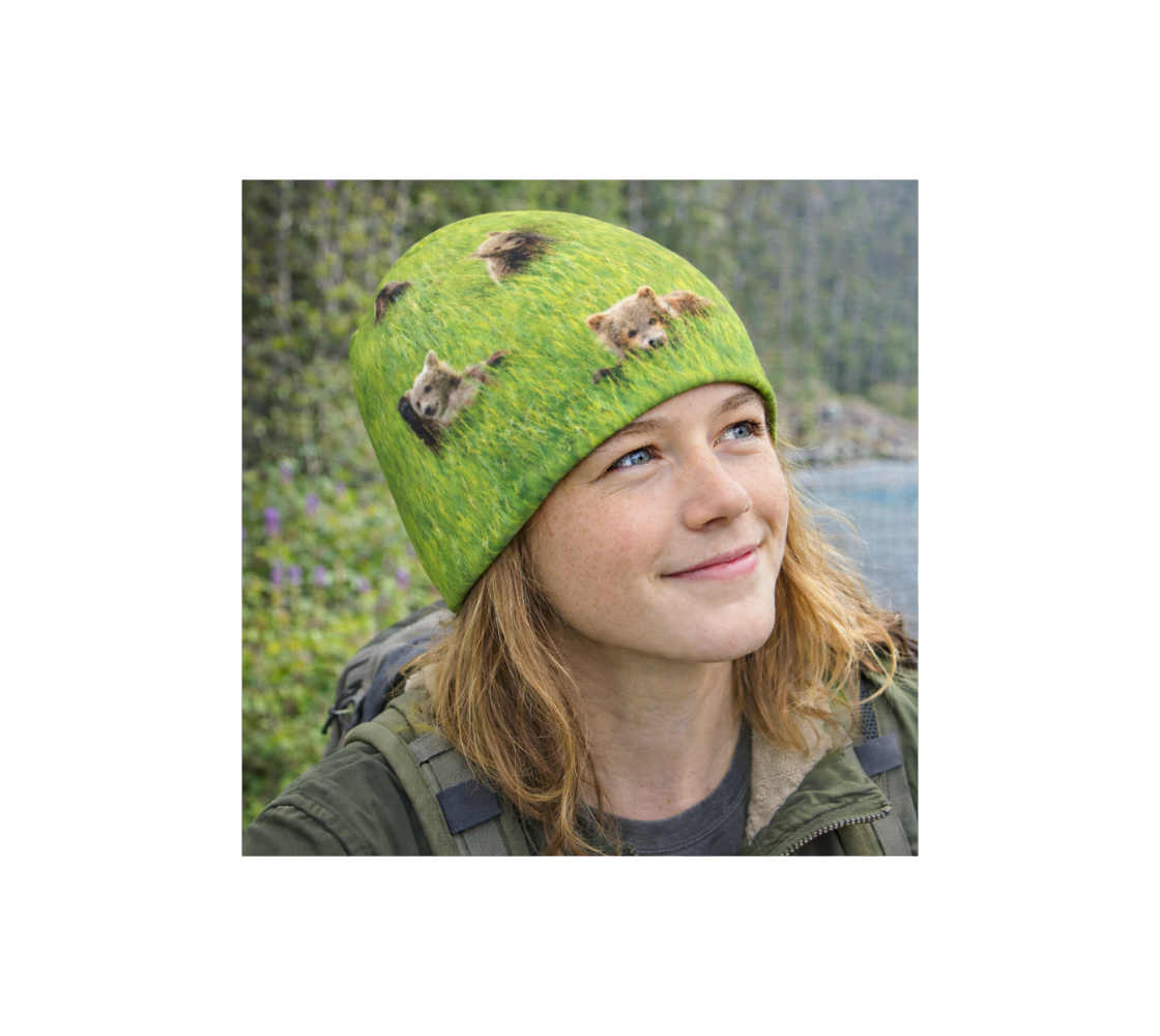 Young girl outdoors in nature wearing a beanie with  image of multiple baby  bears.