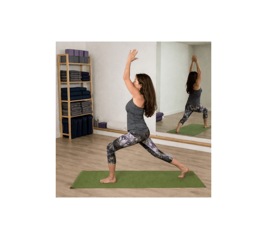 A woman doing yoga wearing a pair of gray wolf classic capri leggings from our real wildlife photography in a studio.