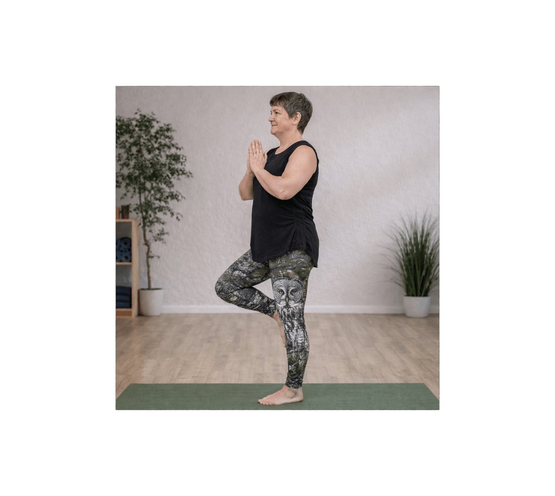 A woman doing yoga wearing a pair of great gray owl yoga leggings from our real wildlife photography in a studio. 