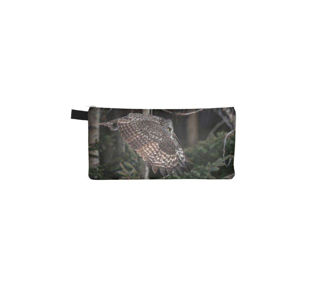 This durable double sided 9” x 4” canvas zippered pouch features 2 real photos of a great grey owl. On this side is a great grey owl in flight in mid-air with it wings flapped downward as it flies through the evergreen forest in the background. 