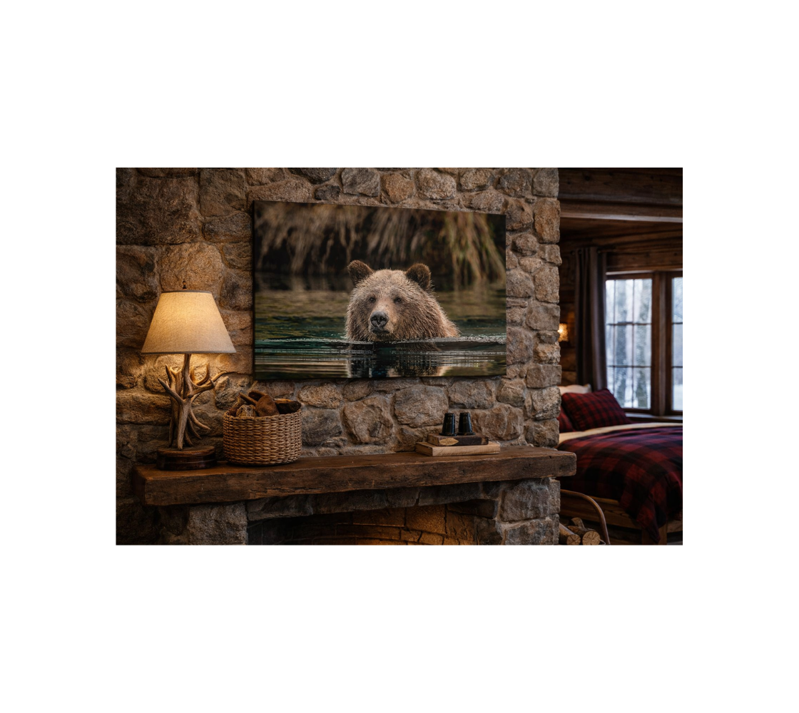 Stone fireplace in a cozy bed room with a canvas print of a grizzly bear in blue water.