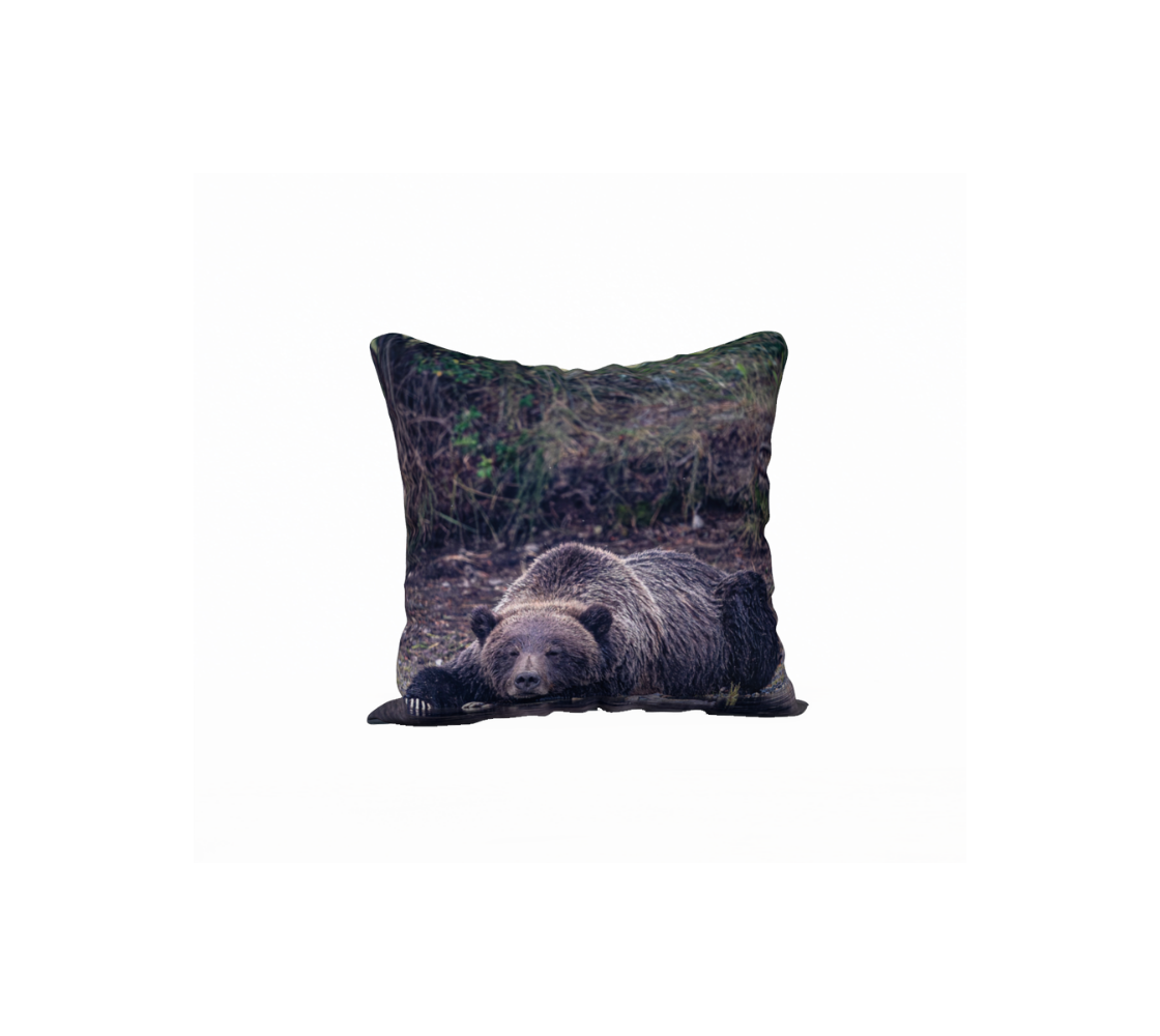 A throw pillow cover with a grizzly bear design on a brown background.
